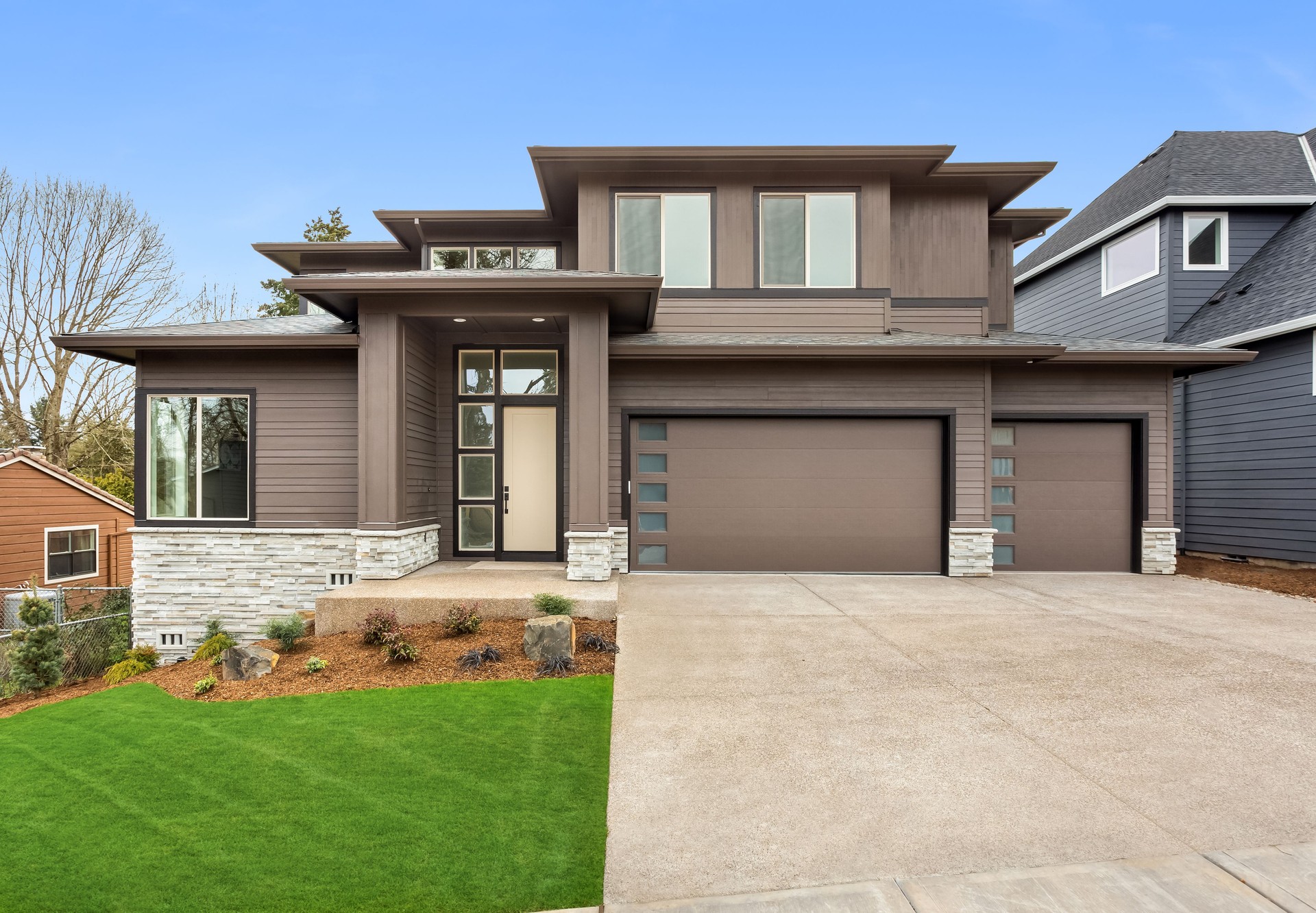 Beautiful suburban home exterior on bright sunny day with green grass and blue sky